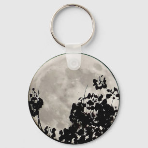 Porte-clés Lune derrière des feuilles sombres