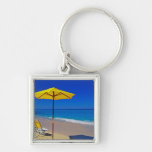 Porte-clés Parapluie de plage jaune et chaises sur une plage