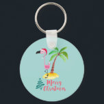 Porte-clés Pink Flamingo In A Santa Hat By A Palm Tree Xmas<br><div class="desc">Keychain with a cute illustration of a pink flamingo in a red santa hat. Standing beside a green palm tree on a mound of yellow sand. A fancy swirly christmas tree design is placed beside the text Merry Christmas. Written in the color pink in a fancy handwritten font. Pastel green...</div>