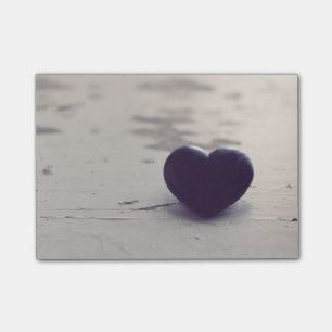 Post-it® Coeur en pierre pourpre émouvant sur une plage