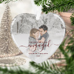 Premier Noël Engagé Photo Rouge Script Coeur<br><div class="desc">Commémorez votre fiançailles avec ce magnifique ornement en forme de coeur. Le texte rouge foncé dit "Notre premier Noël engagé", avec le mot "engagé" dans un élégant script d'écriture manuscrite avec des fioritures avant et après. Remplacez l'exemple d'image par votre photo préférée, et ajoutez vos noms et l'année. Un filtre...</div>