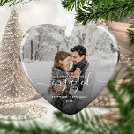 Premier Noël Engagé Photo White Script Coeur<br><div class="desc">Commémorez votre fiançailles avec ce magnifique ornement en forme de coeur. Le texte blanc dit "Notre premier Noël engagé", avec le mot "engagé" dans un élégant script d'écriture manuscrite avec des fioritures avant et après. Remplacez l'exemple d'image par votre photo préférée, et ajoutez vos noms et l'année. Un filtre dégradé...</div>