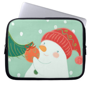 Protection Pour Ordinateur Portable Un bonhomme de neige accrochant un ornement sur un