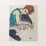 Puzzle de femme posé par Schiele d'Egon<br><div class="desc">Puzzle de femme posé par Schiele d'Egon. Crayon, gouache, et aquarelle sur le papier à partir de 1917. Un des travaux les plus célèbres d'Egon Schiele autrichien d'artiste, femme assise avec le genou coudé comporte un roux assez jeune utilisant les collants noirs reposant sa joue sur son genou. Un beau...</div>