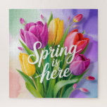 Puzzle "Spring is Here" Tulip Bouquet Illustration<br><div class="desc">A vibrant and cheerful digital illustration featuring a lush bouquet of tulips in shades of purple, yellow, and coral pink. The bouquet is overlaid with elegant, white cursive typography that reads "Spring is here". The background consists of soft, painterly watercolor washes in pastel green, purple, and peach.</div>