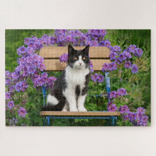 Puzzle Tuxedo cat sitting on a garchair with flowers