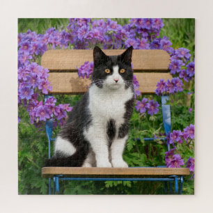 Puzzle Tuxedo cat sitting on a garchair with flowers