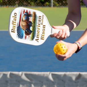 Raquette De Pickleball Buffle debout dans le champ d'herbe avec drapeau a