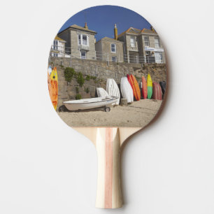 Raquette De Ping Pong Kayaks et yoles empilés contre le mur de mer à