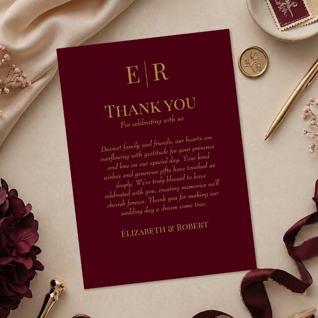 Remerciements Carte de remerciement de mariage élégante avec mon (Elegant Burgundy Monogram Wedding Thank You Card on a table with burgundy wedding decor)