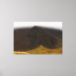 Roche volcanique noire et toile de nuages bas