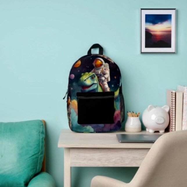 Sac À Dos Imprimé Astronaute sur Dino dans l'espace  (Backpack – D: 17"x12.5"x5" Two-chamber design with laptop storage pouch. Mesh side pocket.
 
)