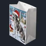 Sac Cadeau Moyen Greyhound Winter Wonderland Christmas Joie<br><div class="desc">Ce design festif reflète l'esprit joyeux de la période des fêtes, avec un adorable petit portant un chapeau de Père Noël. Le chien est niché dans un pays des merveilles hivernales, avec un bonhomme de neige, un sapin de Noël décoré et des cadeaux joliment emballés. Les flocons de neige tombent...</div>