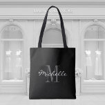 Sac fourre-tout monogramme noir et blanc glamour<br><div class="desc">Sac fourre-tout monogramme noir et blanc glamour. Design élégant monogrammed avec typographie de script pour nom personnalisé. Ajoutez votre propre lettre initiale personnalisée. Soirée classique pour cadeau idée pour mariage chic, fête d'anniversaire, anniversaire, bachelorette, fiançailles, week-end filles, douche nuptiale etc. Couleur arrière - plan personnalisable. Accessoires tendance pour femmes et...</div>