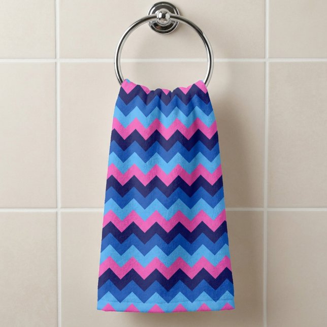 Serviette à main à motif chevron rose bleu clair (Cool Blue Pink Chevron Pattern Hand Towel hanging on a towel ring in a bathroom.)