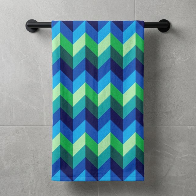 Serviette de bain à chevrons dégradés bleu-vert (Blue Green Ombre Chevrons Bath Towel hanging on a towel rod against a wall in modern style bathroom.)