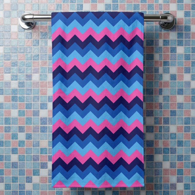 Serviette de bain à motif chevron bleu rose (Cool Blue Pink Chevron Pattern Bath Towel hanging on a rack in a bathroom against tiled wall.)