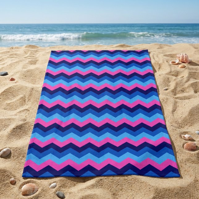 Serviette de plage à motif chevron bleu rose Cool (Cool Blue Pink Chevron Pattern Beach Towel laying on sandy beach near an ocean.)
