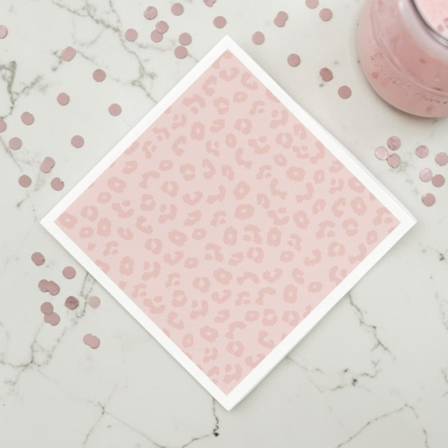 Serviette En Papier Impression léopard en rose (A pink leopard print napkin on a white marble countertop with muted pink confetti and a pink drink.)