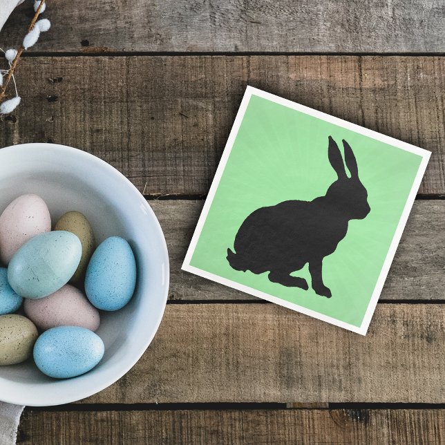 Serviette En Papier Silhouette de lapin noir forme de grandes oreilles (Black sitting bunny rabbit on green paper napkin for spring or Easter.)