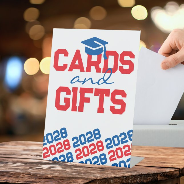 Signe De Table Cartes rouges et bleues et cadeaux Tableau de grad (Red, Blue and White Graduation Cap Class Year Cards and Gifts Pedestal Table Sign)