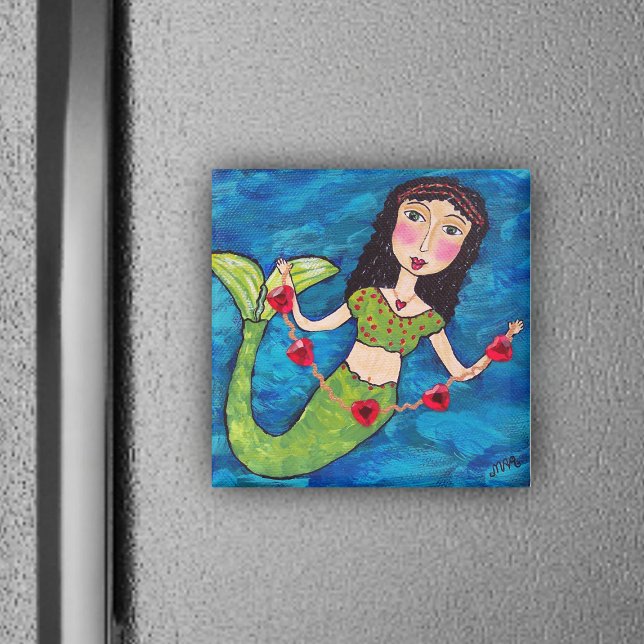 Sirène Avec Aimant Coeur (Mermaid green tail holding gold string of red heats on ocean blue magnet.)