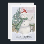 Snowman à Santa Hat Pine Tree Carte de Noël<br><div class="desc">La scène traditionnelle de la carte de Noël comprend un bonhomme de neige aquarelle avec un chapeau de Père Noël et une écharpe verte. Pins, bois de chauffage et palissandre complètent la scène des vacances. Joyeux Noël est écrit ci-dessous dans une police serif élégante. Une deuxième ligne de texte personnalisé...</div>