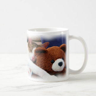 Sommeil Kitty avec la tasse de nounours