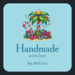 Sticker Carré Fabriqué à la main avec amour Tropical Christmas P<br><div class="desc">Fabriqué à la main avec des autocollants de produits Love avec une image de vacances saisonnière. Un palmier tropical orné de lumières festives surmonté d'une étoile. Un sucre de canne géant rouge et blanc qui sort du sable. Cadeaux de Noël sous l'arbre. Whimsical et amusant.</div>