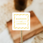 Sticker Carré Mariage de cadre moderne Jaune Wavy<br><div class="desc">Scellez vos enveloppes et faveurs mariages avec des autocollants Modern Yellow Wavy Frame personnalisés ! Le design présente les noms du couple en lettres jaunes en gras entourés d'un cadre ondulé jaune. Les autocollants de mariage rétro ont été conçus pour être coordonnés avec notre collection de mariages Wavy Frame Moderne....</div>