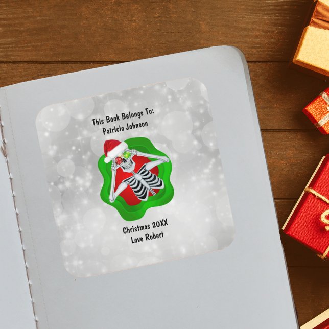 Sticker Carré Noël Squelette Ornements Rouge Vert brillant (Cute Skeleton holding ornaments for eyes Santa Hat in green Red splatter on white book plate sticker)