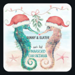 Sticker Carré Seahorse Père Noël Notre premier Noël Marié<br><div class="desc">Les autocollants de Noël à thème côtier (ou enveloppes ou étiquettes cadeaux) comportent un couple d'hippocampes à l'aquarelle sur la plage portant des chapeaux de Père Noël et s'embrassant sous un faux-pied avec une légende qui dit "Notre 1er Noël Marié". Les noms peuvent être personnalisés. Visitez ma collection "Seahorse Coastal...</div>