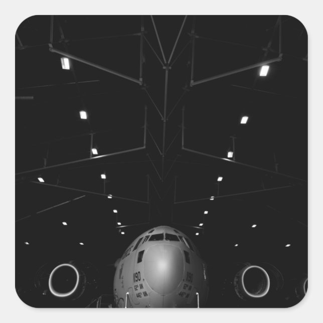 Sticker Carré Un C-17 Globemaster III est assis dans un hangar (Devant)