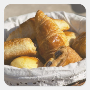 Sticker Carré Un panier de petit-déjeuner en osier avec des croi