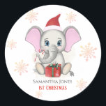 Sticker Rond Baby Girl First Christmas Jote Elephant Holidays<br><div class="desc">Adorable petit éléphant avec un casquette de Noël,  un cadeau de Noël,  tenant un bonbon de canne de Noël et un arrière - plan enneigé avec de beaux flocons de neige. Bébé Fêtes de Noël. Personnalisez en changeant le nom.</div>