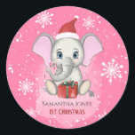 Sticker Rond Baby Girl First Christmas Jote Elephant Holidays<br><div class="desc">Adorable petit éléphant avec un casquette de Noël,  un cadeau de Noël,  tenant un bonbon de canne de Noël et un arrière - plan enneigé avec de beaux flocons de neige. Bébé Fêtes de Noël. Personnalisez en changeant le nom.</div>