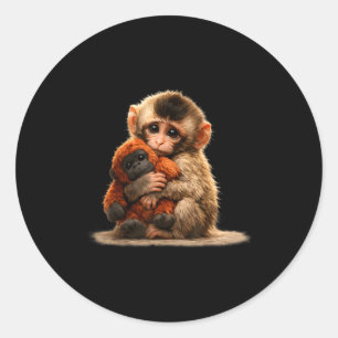 Sticker Rond Bébé singe câlinant une peluche macaque japonais m