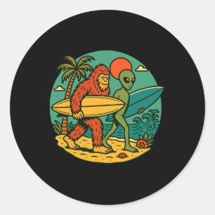Sticker Rond Bigfoot et alien surfant sur l'art de plage vintag