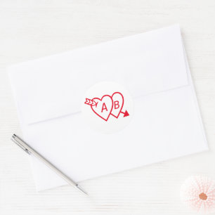 Sticker Rond Cœurs doubles rouges avec la flèche de Cupidon et