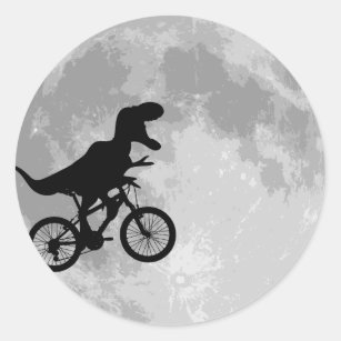 Sticker Rond Dinosaure sur un vélo dans le ciel avec la lune