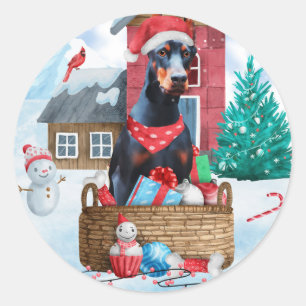 Sticker Rond Doberman dans une maison de Noël enneigée