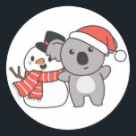 Sticker Rond Koala Avec Snowman En Hiver Pour Noël Classique<br><div class="desc">Koala with snowman en hiver pour Christmas - a snowman for winter and Christmas. A winter greeting in the cold season for the holidays. Christmas koala with snowman.</div>