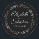 Sticker Rond Lacy Silver Filigree Élégant Mariage noir<br><div class="desc">Ces élégants autocollants de mariage présentent du texte de script gris pâle sur un arrière - plan noir avec une bordure florale en faux feuille argent en dentelle. Le texte est entièrement personnalisable et contient les noms du couple mariage et la date du mariage. Super comme des étiquettes de faveur...</div>