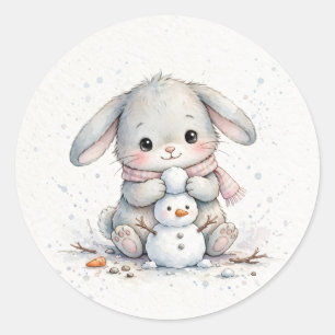 Sticker Rond Lapin construisant un bonhomme de neige de Noël