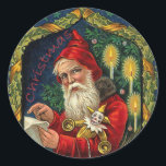 Sticker Rond Liste de Noël Vintage de Père Noël<br><div class="desc">Cette image vintage est un Père Noël à l'ancienne habillé de la tenue traditionnelle de cape rouge. Il vérifie sa liste avec des jouets en or. Il est entouré de bougies brillantes, encadrées de lierre avec un arrière - plan bleu étoilé. Voir mon magasin Art by MAR pour apparier les...</div>