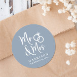 Sticker Rond M. Mme Dusty Mariage bleue<br><div class="desc">Des autocollants bleus poussiéreux personnalisés pour votre correspondance mariage et des faveurs avec "M. & Mme" écrit dans un grand script blanc et une illustration blanche de deux anneaux mariages réunis. Ajoutez votre nom et votre date de mariage.</div>