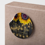 Sticker Rond Mariage de tournesol en bois rustique merci pour<br><div class="desc">Mariage de texte modifiable merci autocollant avec rustique grand beau tournesol sur un arrière - plan en bois de grange brun foncé avec lumières à cordes. Idéal pour votre été ou automne élégant jardin de campagne rustique ou mariage de ferme. Personnalisez-le avec les noms de la mariée et du marié...</div>