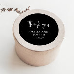 Sticker Rond Mariage noir moderne<br><div class="desc">Ces autocollants modernes,  simples et élégants de mariage noir foncé ou de douche nuptiale présentent un design minimaliste de texte blanc avec un script manuscrit élégant qui dit "merci".</div>