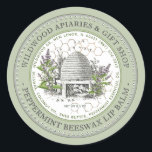 Sticker Rond Mint Beeswax Lip Balm Vintage Skein dans Mint Gard<br><div class="desc">Étiquette Lip Balm personnalisé avec l'illustration vintage d'une ruche d'abeilles entourée d'un vieux jardin avec fleurs sauvages,  menthe sauvage et petites abeilles. Bordure circulaire pointillée. Motif peigne de miel en arrière - plan. Personnalisez avec votre nom,  votre prénom,  votre emplacement,  votre numéro de cellule et votre liste d'ingrédients.</div>