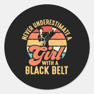 Sticker Rond Ne Sous-Estimez Jamais Une Fille Avec Une Ceinture